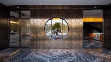 A lobby with a circular window, a reception desk, and a patterned floor.