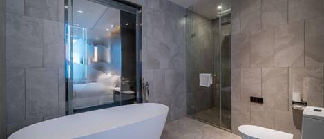 A modern bathroom with a freestanding bathtub, a glass-enclosed shower, and a toilet.