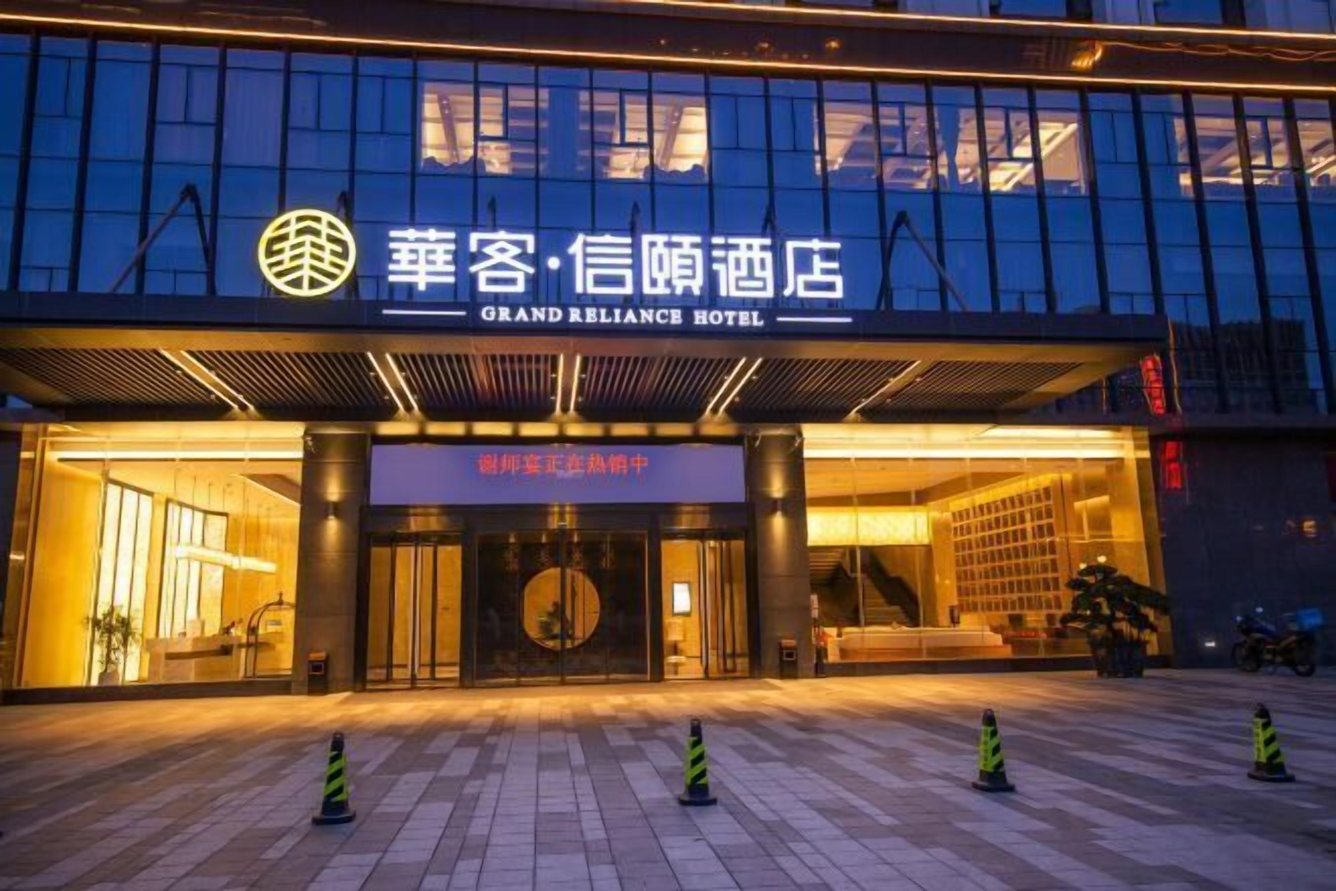 The exterior of the Grand Reliance Hotel with a modern facade and illuminated entrance.