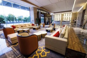 A modern lobby with seating areas, a reception desk, and large windows. - Huake Xinyi Hotel (Zhuzhou)