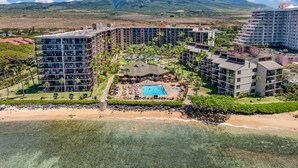 A resort with multiple high-rise buildings, a central pool area, and a beach.