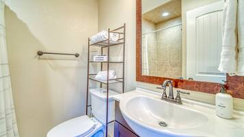 Een bad/douchecombinatie, een haardroger, handdoeken, toiletpapier