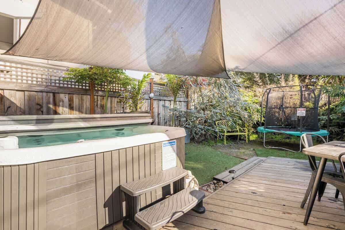 Ein Whirlpool mit Treppen, ein Trampolin und eine Holzterrasse.