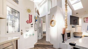 A modern interior with a kitchen area, a dining space, and a staircase leading to another level. - Aptos Beach Retreat Hot Tub & 5 Min Walk to Sand (Aptos)