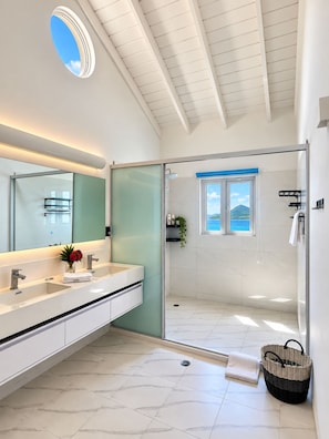 A modern bathroom with a large mirror, a shower with a view, and a white tiled floor. - Private Caribbean Cottage with Ocean & Nevis Views near Cockleshell Beach (Basseterre)