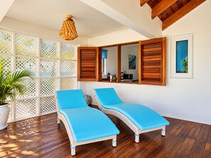 A sunlit room with two lounge chairs, a wooden ceiling, a white wall, and a window with wooden shutters. - Private Caribbean Cottage with Ocean & Nevis Views near Cockleshell Beach (Basseterre)