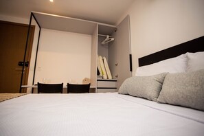 A hotel room with a bed, a desk, and a wardrobe.