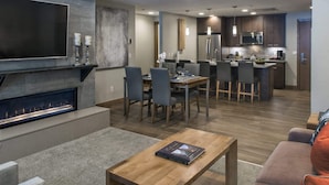 Un salon moderne doté d’une cheminée, d’un coin repas et d’une cuisine.