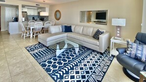 A modern living room with a sectional sofa, a glass coffee table, and a patterned rug. - Luxury Ocean Front (Murrells Inlet)