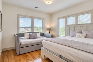 Une chambre avec deux lits, un canapé et une lampe.