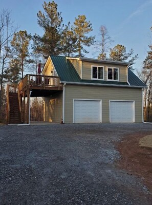 Une maison à deux étages avec un porche couvert et un garage.