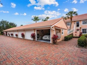 Une maison à deux étages avec un garage, une allée couverte et un petit porche.