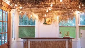 Eine Bar mit rustikalem Design, mit einer Holztresore, drei Barhocker und einem Schild mit der Aufschrift 'BEER'.