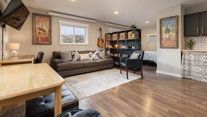 A cozy living room with a sofa, a dining table, and a bookshelf. - Studied Perfection (Spearfish)