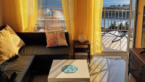 Ein modernes Wohnzimmer mit einer Couch, einem Couchtisch und Blick auf das Meer.