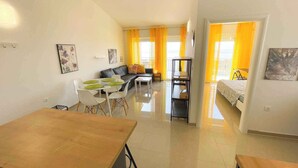 Eine moderne Wohnung mit Essbereich, Wohnzimmer und Schlafzimmer.