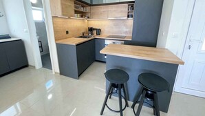 Eine moderne Küche mit Kochinsel, Barhocker und integriertem Backofen.