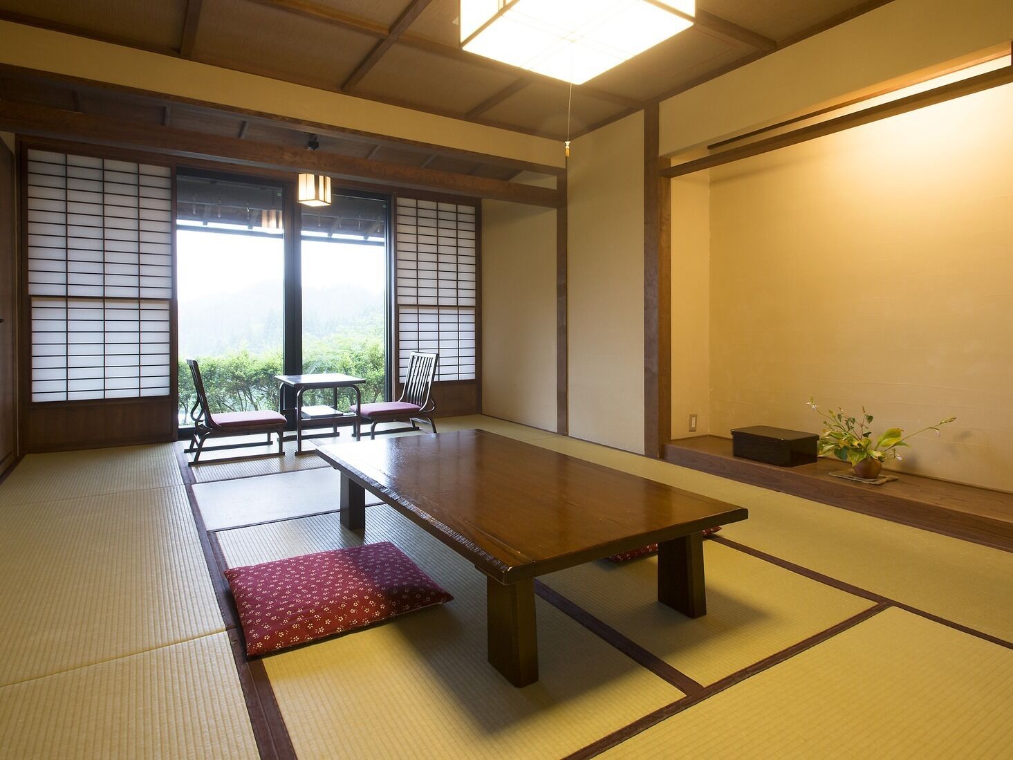 A traditional Japanese room with tatami flooring, a low table, and sliding doors.