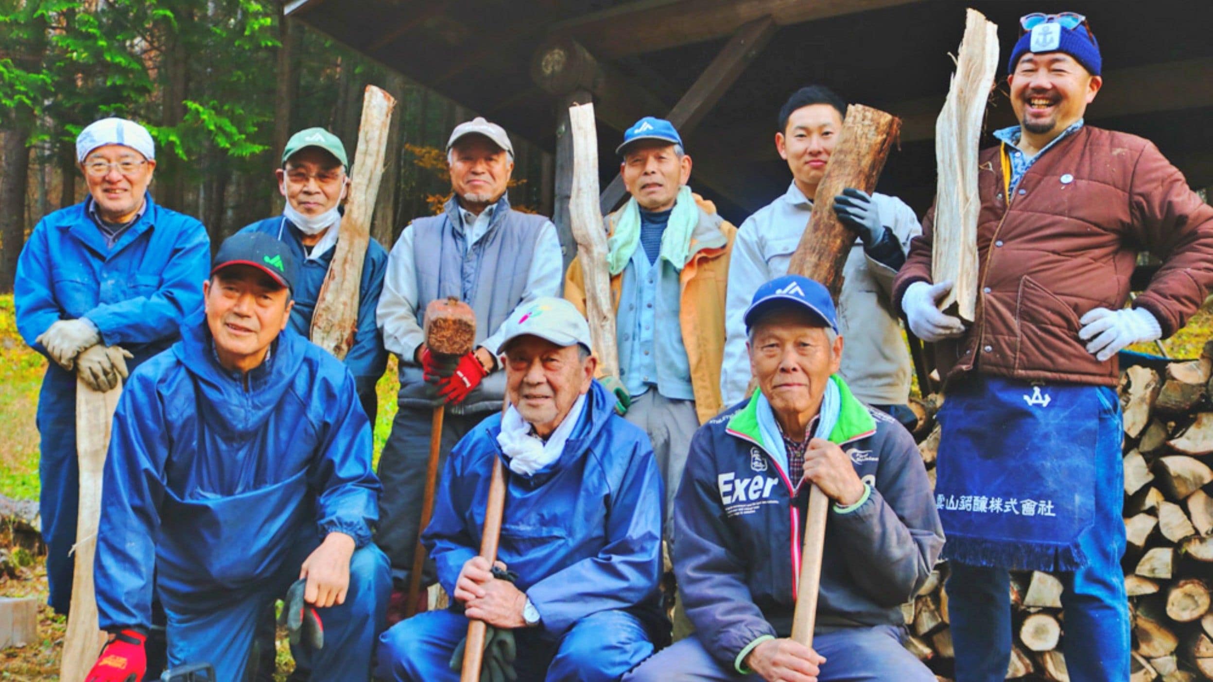A group of people outdoors, some holding tools, possibly engaged in a work activity.
