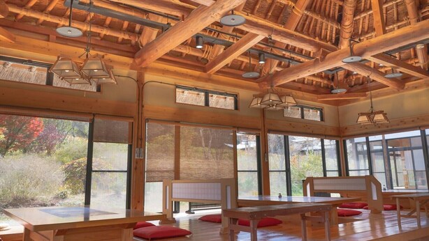 A spacious room with wooden beams and large windows offering views of the outdoors. - Green Village Yokokawa Kayabuki No Yakata (Tatsuno)