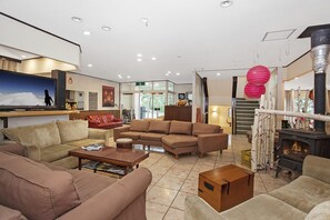 A spacious living area with a fireplace, sofas, and a television.