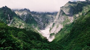 Een bergachtig landschap met weelderige begroeiing en een dal.