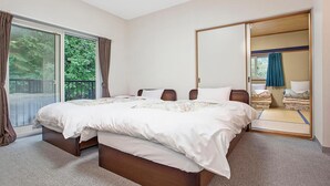 Een slaapkamer met een groot bed, een schuifdeur naar een balkon en een spiegel in volle lengte.