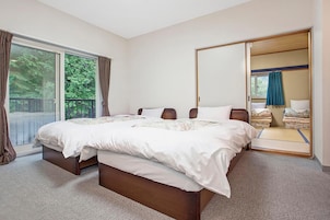 Un dormitorio con una cama grande, una puerta corredera a un balcón y un espejo de cuerpo entero.
