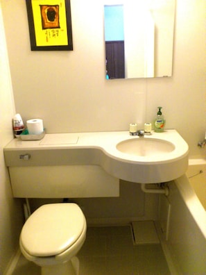 A bathroom with a toilet, sink, and mirror. - Tenjin Lodge (Minakami)