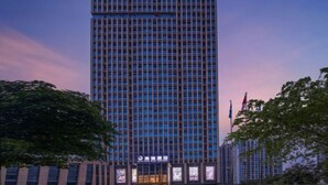 A tall, modern hotel building with a grid of windows and a sign indicating it is a hotel. - Hairui Hotel (Chongqing)
