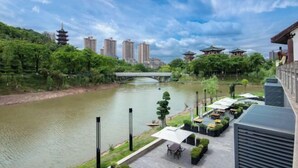 A riverside view with a traditional pagoda, modern buildings, and a bridge. - Hairui Hotel (Chongqing)