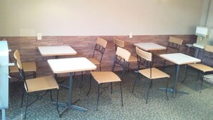 A dining area with tables and chairs, a wooden accent wall, and pendant lighting. - Free Days Inn Yokogawara (Toon)