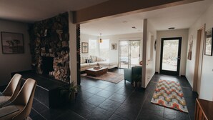 A modern living room with a stone wall, a fireplace, a sofa, and a coffee table.