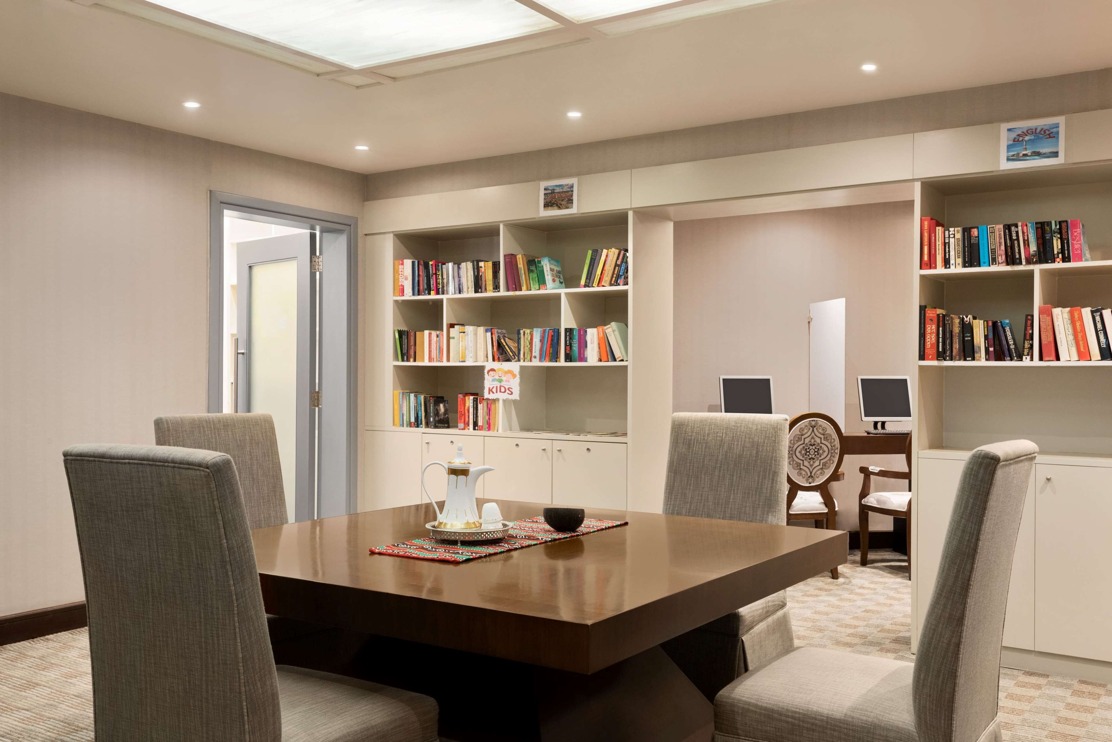 A conference room with a large table, chairs, and bookshelves filled with books.