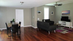 A living room with a sofa, TV, and a dining area with chairs and a table. - 3 Bedroom House in Fort Recovery (Fort Recovery)
