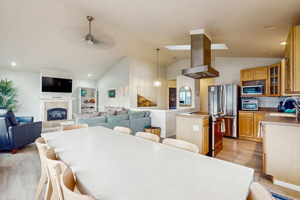Enjoy a spacious living area with a dining table, comfortable seating, and a cozy fireplace.