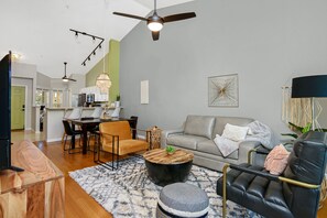 A modern living room with a sofa, coffee table, and chairs. There is a dining area with a table and chairs. The room has a ceiling fan and pendant lights. - 5*Star Coral Falls, 2BR Condo, Naples FL USA, 15min drive to many beaches, shops (Naples)