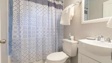 Kombinert dusj/badekar, håndklær og toalettpapir