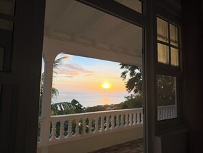 A balcony with a view of the sunset over the sea. - Ocean View Retreat • 2BR • 20 Min from Roseau (Mahaut, Saint Paul Parish)