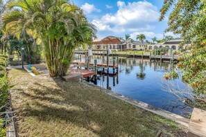 Enjoy a peaceful waterfront retreat with a tranquil pool area, dock, and lush surroundings.