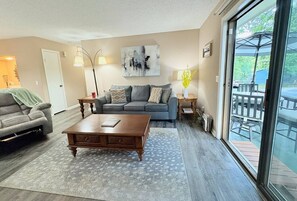 A living room with a sofa, a coffee table, and a floor lamp.