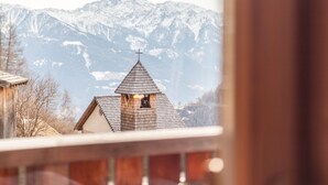 A mountain view with a church and snow-covered peaks.