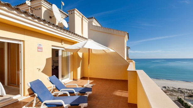A balcony with sun loungers, a white umbrella, and a view of the sea. - Beachfront Penthouse with Wi-fi & Pool (San Javier, Murcia)