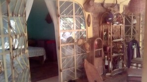 A room with a bed, a window, and a shelf with various items.