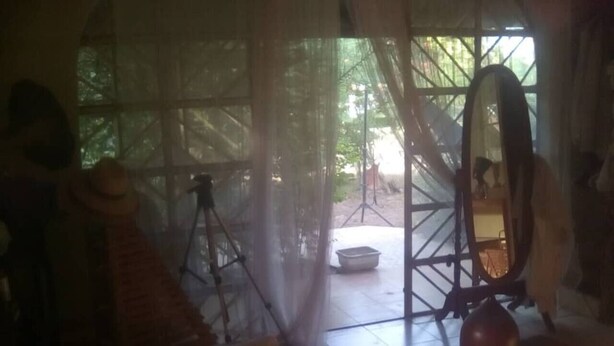 A room with a large window, a tripod, and a mirror.