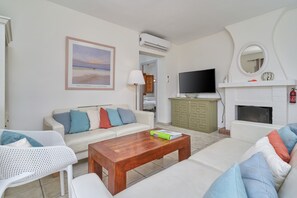A living room with a sofa, coffee table, TV, fireplace, and a framed picture on the wall. - Villa "Casa Bonita" with Stunning Views & Heated Pool (Salobreña)