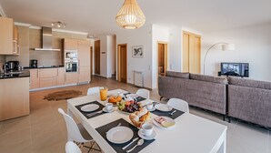 A modern apartment with a dining area, kitchen, and living room. - Apartment 'Beachfront Atlantic View A09' with Sea View and Wi-Fi (Óbidos)