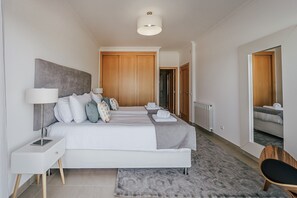 Een moderne hotelkamer met een groot bed, nachtkastjes, een spiegel en een radiator.