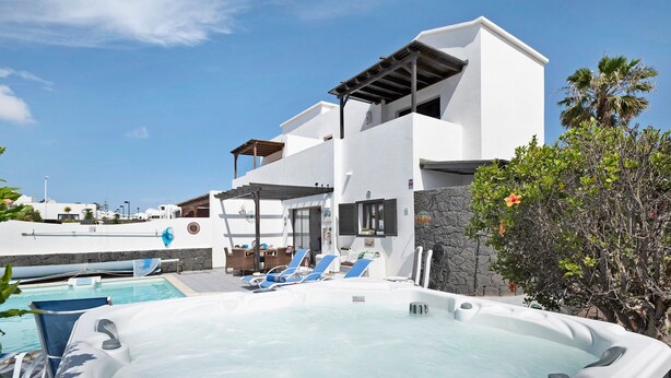 A modern hotel with a hot tub, lounge chairs, and a pool. - 'Casa Hibiscus' with Private Pool, Jacuzzi, Terrace & Garden (Playa Blanca)