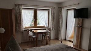 A bedroom with a bed, a desk, and a TV.